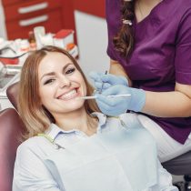 Beautiful lady in the dentist's office. Woman in a purple uniform